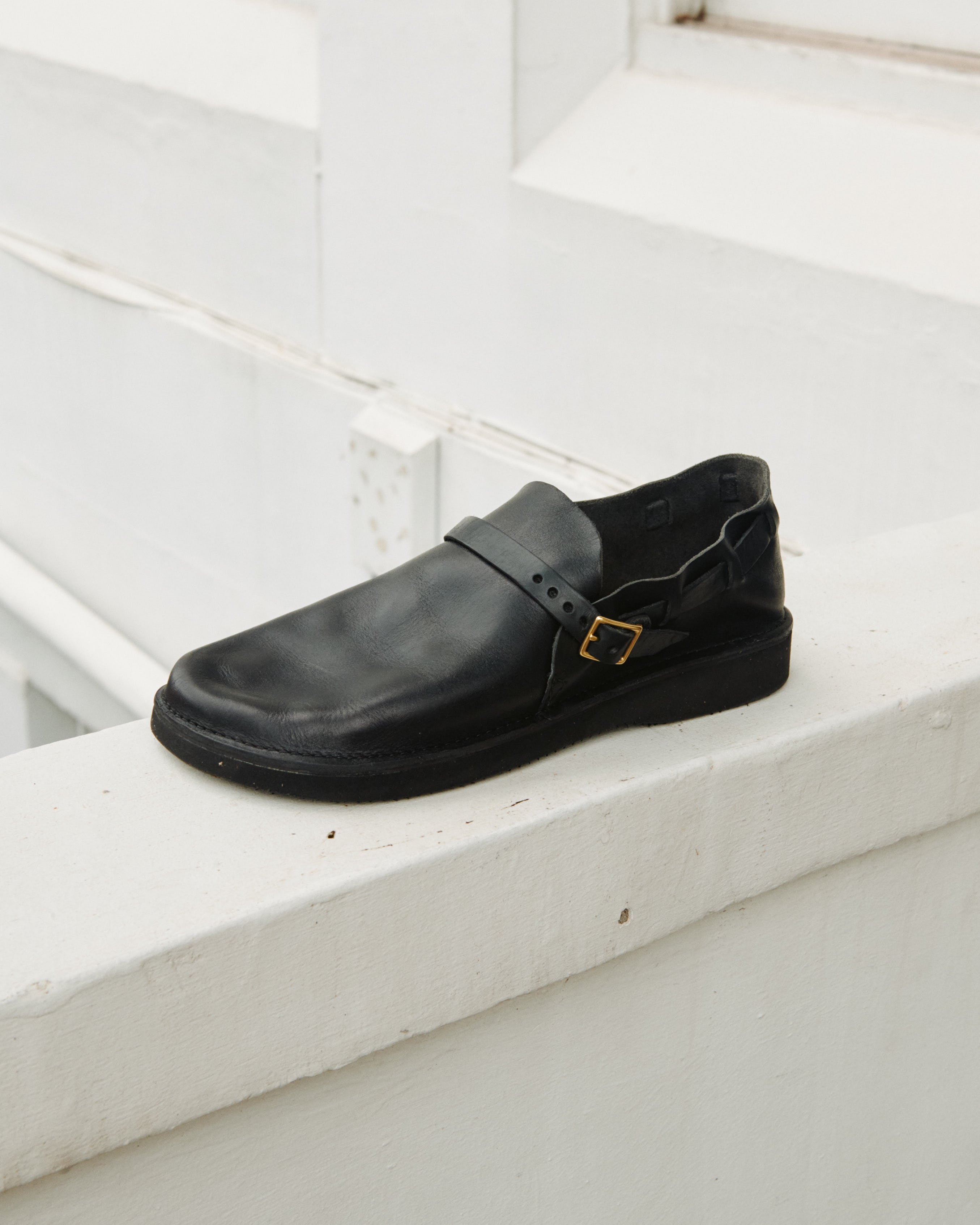 Lifestyle view of Aurora Middle English black Chromexcel leather strap shoe with brass buckle