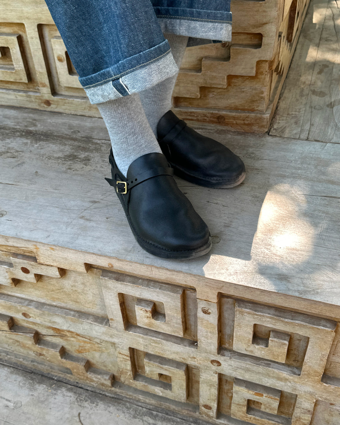 Lifestyle detail of black Aurora Middle English leather strap shoes styled with denim jeans