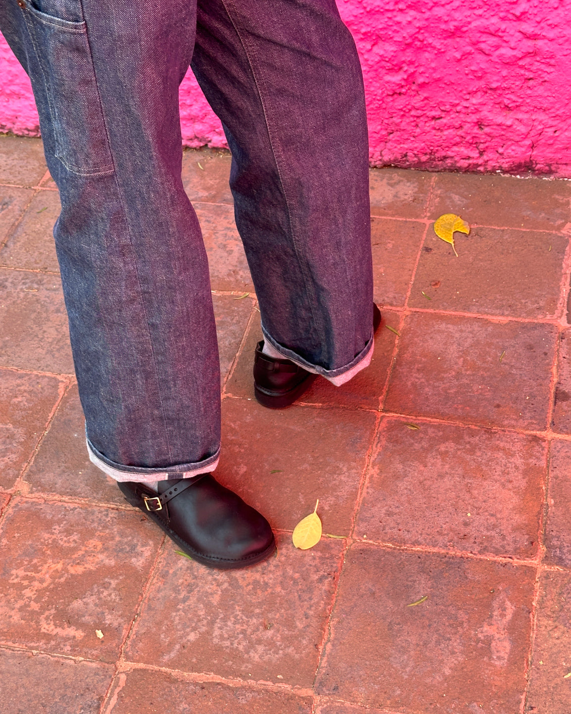 Lifestyle detail of black Aurora Middle English leather strap shoes with denim jeans