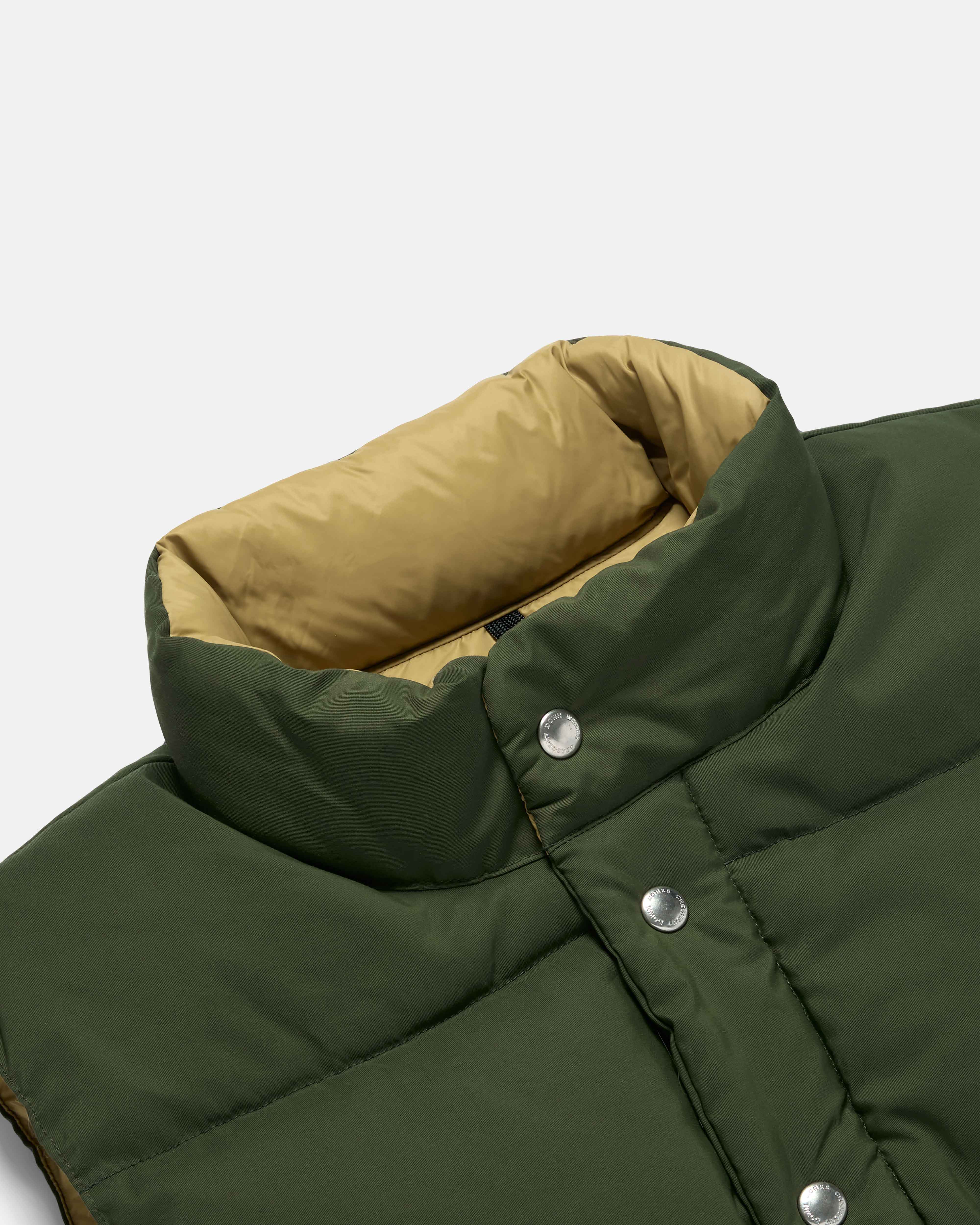 Close-up of snap front on olive Crescent cotton nylon vest