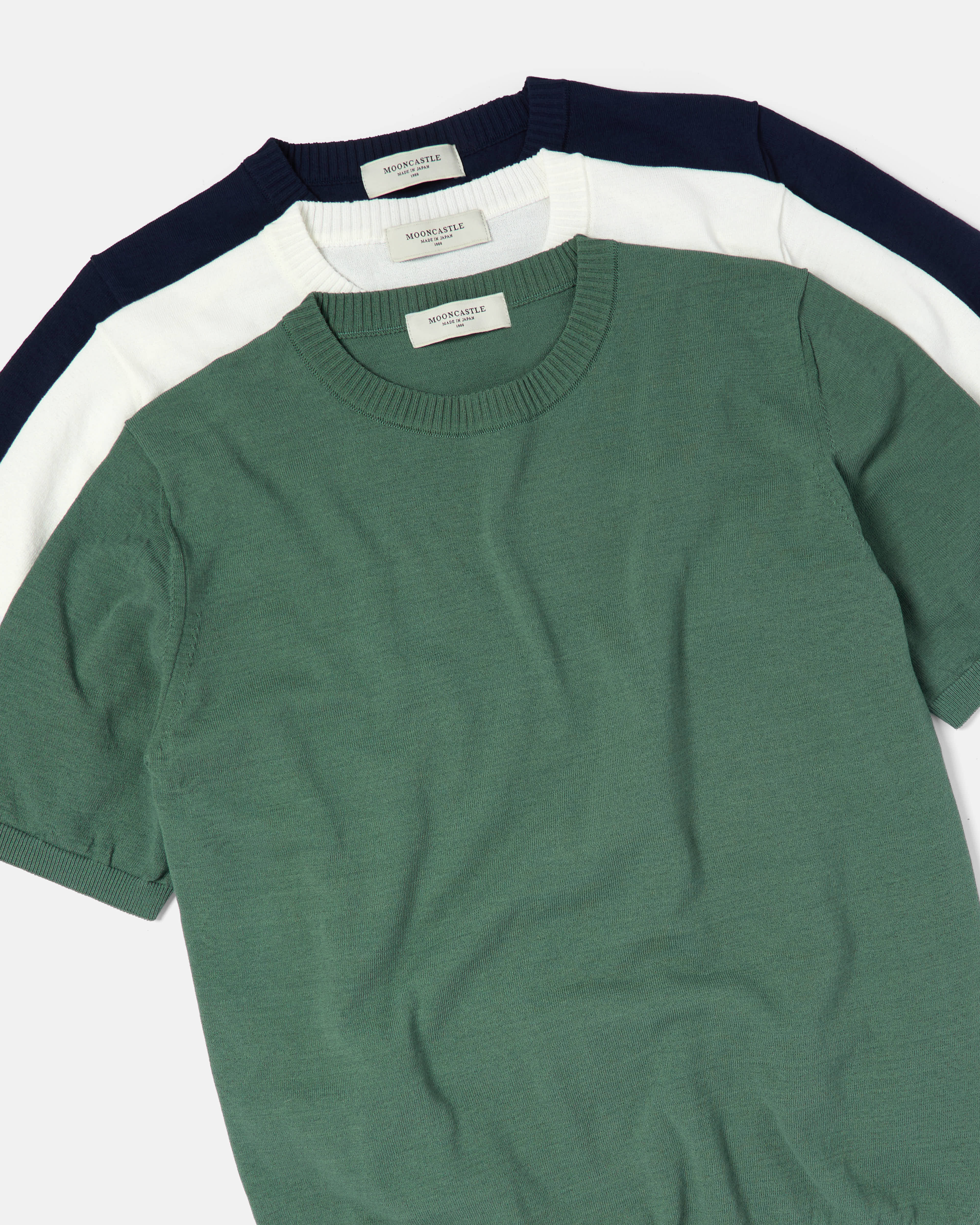 Flat lay of Mooncastle ice cotton crewneck T-shirts in green, white and navy